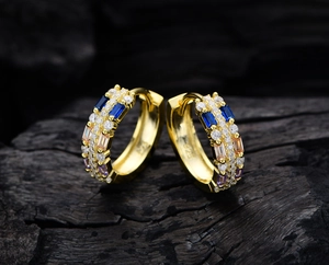 Macro detail of S925 sterling silver stamp on colorful zircon gold hoop earrings