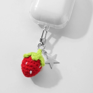 Handmade crochet strawberry and silver star pendant on a clear earphone case