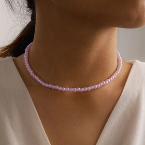 Close-up of elegant lavender pearl necklace worn by a model, featuring smooth round pearls
