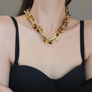 Dettaglio della collana a catena grossa in oro e resina leopardata su modella