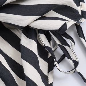 Detail of black and white striped fabric showing tie-up drawstring and fine stitching
