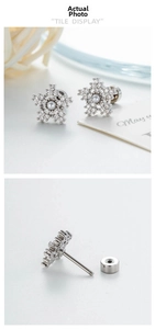Macro detail of snowflake earring with micro-paved cubic zirconia, pearl, and screw back