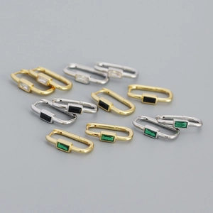 Detail of U-shaped silver earrings with colorful rectangular zircon in gold and silver