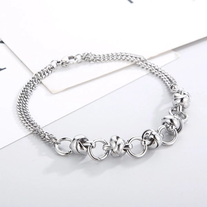 Detail view of silver stainless steel bracelet featuring knotted design and layered chains