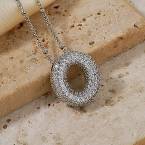 Détail d'un collier avec pendentif circulaire serti de zircons brillants sur pierre