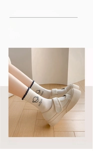 Gros plan de chaussettes blanches avec bords volantés bleus et broderie d'étoiles