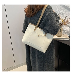 Mannequin portant un grand sac cabas crème avec des anses kaki pour un style quotidien chic