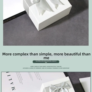 Macro shot of white minimalist jewelry gift box featuring a silver grey satin bow detail