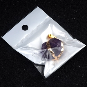 Amethyst raw gemstone pendant with gold-plated edges on a black glitter background