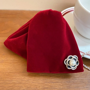 Détail de la pochette à bijoux en velours rouge avec fleur de camélia et perles sur bois