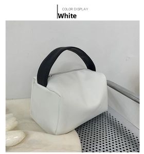 Macro view of white PU leather crossbody bag with contrasting black wide handle