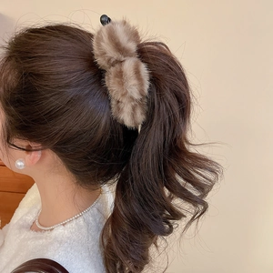 Détail d'une grande pince à cheveux en fausse fourrure rayée pour coiffures d'automne