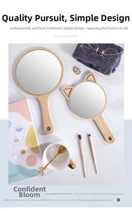 Detailed overhead shot of round and cat-ear shaped wooden hand mirrors on a dressing table