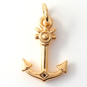 Macro detail of golden anchor charm featuring helm design and polished metal texture