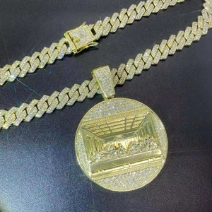 Close-up of golden iced-out Cuban chain and The Last Supper pendant with cubic zirconia