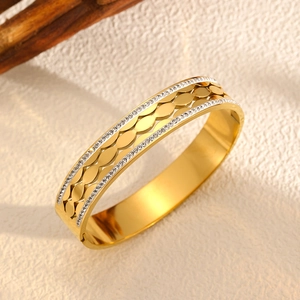 Détail macro du bracelet plaqué or 18k avec double rangée de zircons et motif feuille évidé