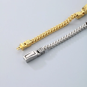 Detail of vintage gold and silver stainless steel bracelets with engraved box clasp