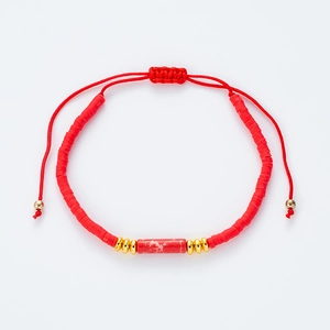Detaillierte Makroansicht des roten Perlenarmbands mit goldenen Perlen und Kordelzug