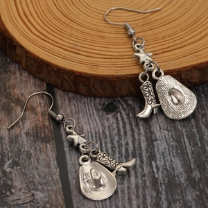 Vue détaillée de boucles d'oreilles vintage argentées avec breloques de bottes et chapeau