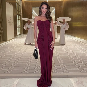 Detail of elegant dark red strapless maxi dress featuring stylish gathered ruched design