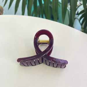 Détail macro de la grande pince à cheveux bordeaux avec ressort en métal doré durable
