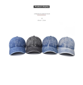 Detailed view of washed denim baseball caps in dark, medium, light blue and charcoal colors