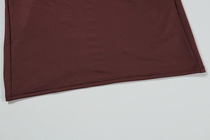 Detail of double-stitched hem on a dark reddish-brown knit dress with smooth texture