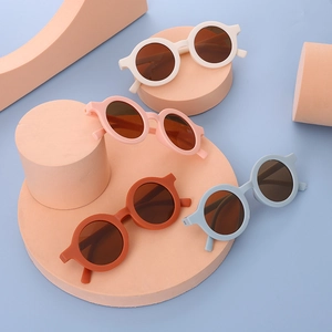 Detailed top view of retro round children's sunglasses in white, pink, orange, and blue