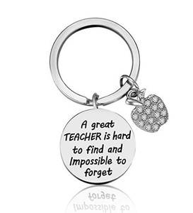 Macro shot of stainless steel teacher keychain with engraved message and crystal apple charm