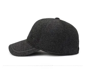 Side view of dark grey wool blend baseball cap with ear flaps and metallic detail
