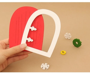 Close-up of DIY dollhouse miniature wooden Christmas door kit with festive wreaths
