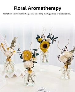 Detail of essential oil diffuser set with preserved flowers and relief glass bottles