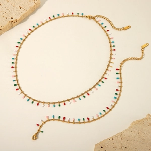 Detail of gold-tone stainless steel jewelry set with colorful hanging water drop beads