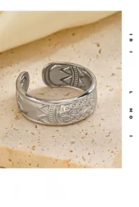 Detailed macro view of vintage silver open ring with embossed floral patterns and geometric lines