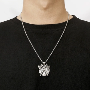 Close-up of model wearing a vintage Viking shield pendant with crossed axes on a chain