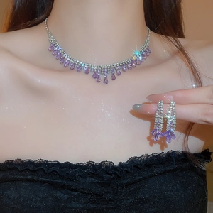 Detail of luxury water drop jewelry set with purple crystals and silver tassels