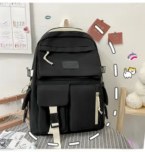 Detail of black multi-pocket nylon backpack showing front flap and side buckle strap