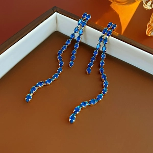 Detailed shot of elegant blue crystal long tassel earrings in a golden finish box