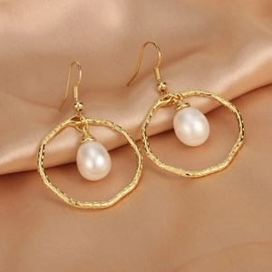 Detail of 18K gold plated hoop earrings with freshwater pearls on champagne silk fabric