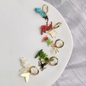 Five pairs of ocean-themed hoop earrings with coral stones and gold sea creature charms
