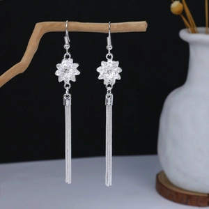 Detail of silver bohemian floral earrings with long tassels on a stylized branch