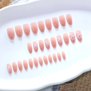 Unghie press-on 3D con sfumatura rosa nude e forma a mandorla su vassoio in ceramica bianco