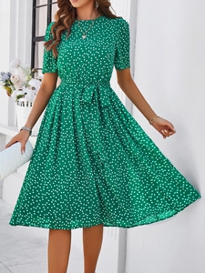 Détail de la robe d'été verte à pois blancs avec taille nouée et manches courtes