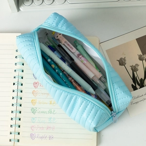 Detail of light blue quilted pencil case with soft texture and smooth zipper closure