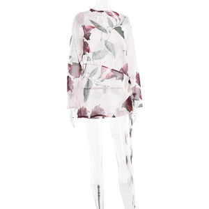 Détail du motif floral sur le tissu semi-transparent de cette robe d'été à manches longues