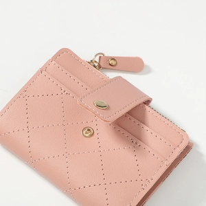 Close-up of pink quilted short wallet with zipper closure and fine stitching details