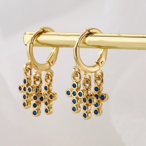 18K gold plated hoop earrings with blue zircon cross pendants on a golden display stand