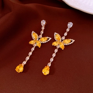 Detail of elegant butterfly earrings with yellow crystal drops and zircon tassels