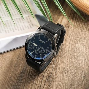 Men's quartz watch with black leather strap on a textured wooden background close-up
