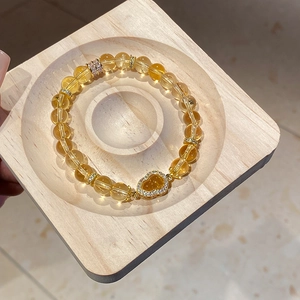 Macro view of tiger eye flower bracelet with gold heart pendant and sparkling zircons